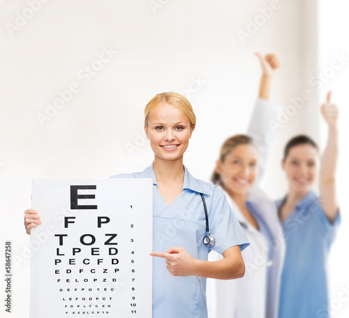 Photo: smiling female doctor or nurse with eye chart smiling female doctor or nurse with eye chart