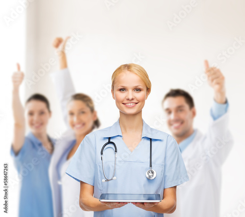 Photo: smiling female doctor or nurse with tablet pc smiling female doctor or nurse with tablet pc