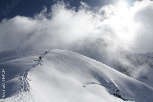 Photo: Skiers climbing a snowy mountain Skiers climbing a snowy mountain