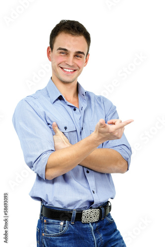 Photo: Trendy man in bluek shirt and jeans pointing something, portrait Trendy man in bluek shirt and jeans pointing something, portrait