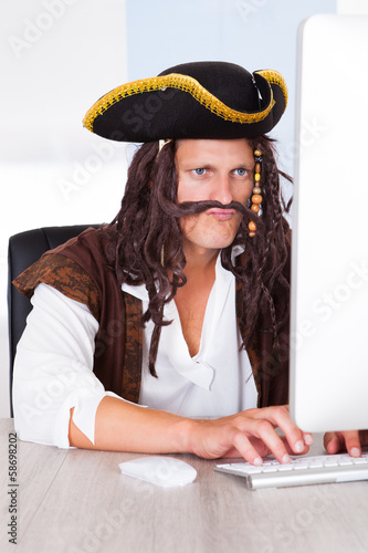 Photo: Pirate Using Computer Pirate Using Computer