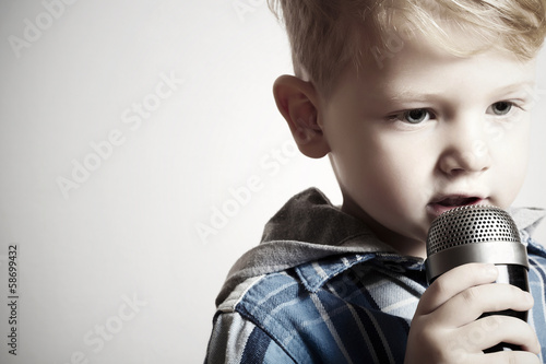 Photo: little boy singing into a microphone. child in karaoke.fashion little boy singing into a microphone. child in karaoke.fashion