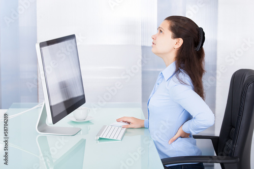 Photo: Businesswoman Suffering From Back Pain Businesswoman Suffering From Back Pain