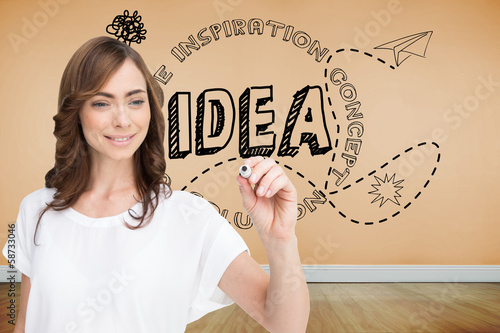 Photo: Composite image of smiling businesswoman holding marker Composite image of smiling businesswoman holding marker