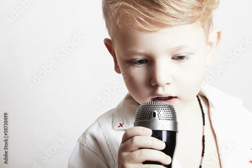 Photo: little boy singing in microphone.child in karaoke.music little boy singing in microphone.child in karaoke.music