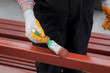 Worker painting steel tube with paint brush focus on hand