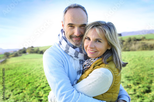 Photo: Senior couple embracing in countryside Senior couple embracing in countryside