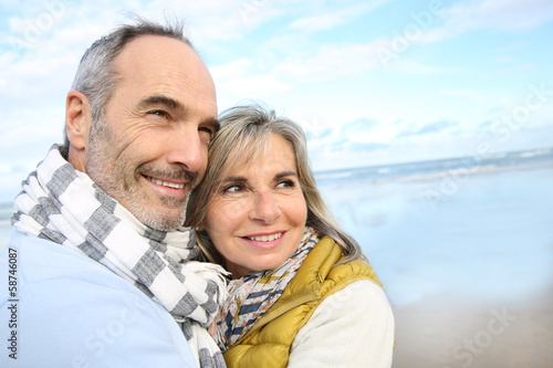 Photo: Portrait of loving senior couple at the beach Portrait of loving senior couple at the beach