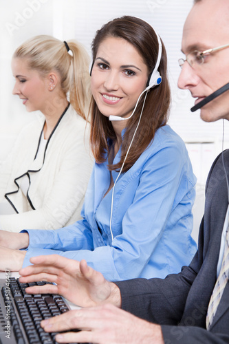 Photo: Mitarbeiter in einem Callcenter mit Headset Mitarbeiter in einem Callcenter mit Headset