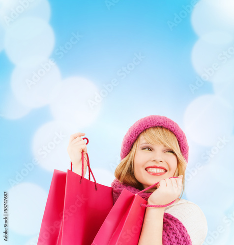 Photo: woman in pink hat and scarf with shopping bags woman in pink hat and scarf with shopping bags