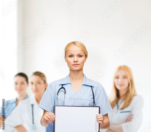 Photo: smiling female doctor or nurse with sclipboard smiling female doctor or nurse with sclipboard