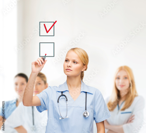 Photo: doctor or nurse drawning checkmark into checkbox doctor or nurse drawning checkmark into checkbox