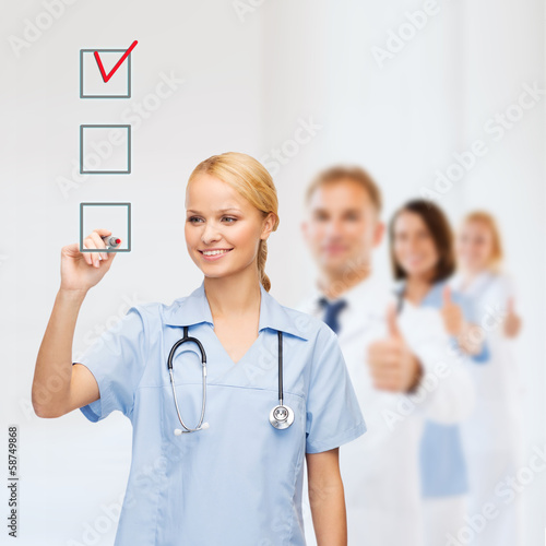 Photo: doctor or nurse drawing checkmark into checkbox doctor or nurse drawing checkmark into checkbox