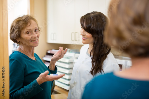 Photo: Optometrist Looking At Woman Holding Contact Lens Optometrist Looking At Woman Holding Contact Lens