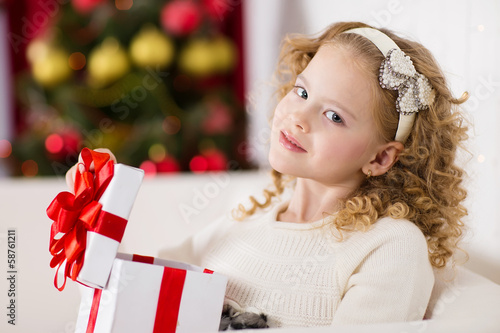 Photo: Portrait of smiling cute girl with Christmas gift Portrait of smiling cute girl with Christmas gift