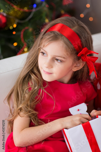 Photo: Adorable curly girl with Christmas present Adorable curly girl with Christmas present