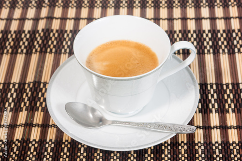 Photo: a cup of coffee on bamboo mat a cup of coffee on bamboo mat