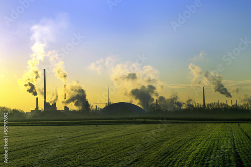 Photo: industry landscape in sunrise with smoking chimneys industry landscape in sunrise with smoking chimneys