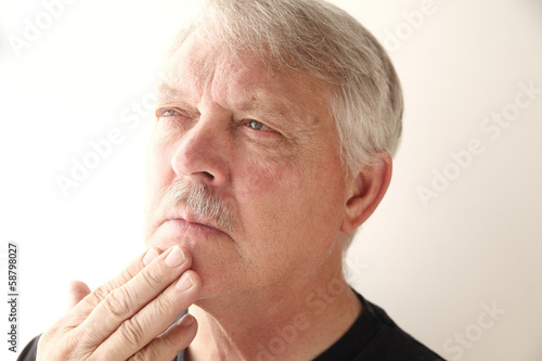 Photo: senior man looks thoughtful senior man looks thoughtful