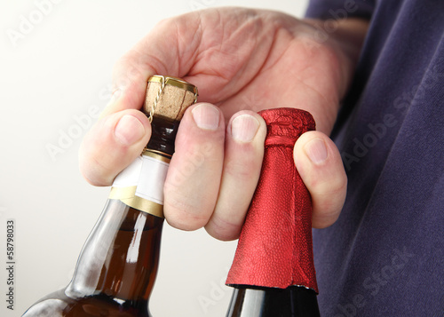 Photo: man holds beer bottles man holds beer bottles
