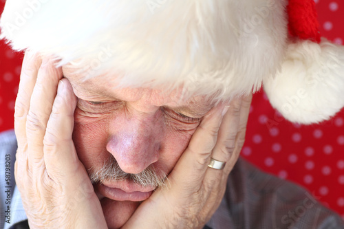 Photo: man looks sad in Santa hat man looks sad in Santa hat