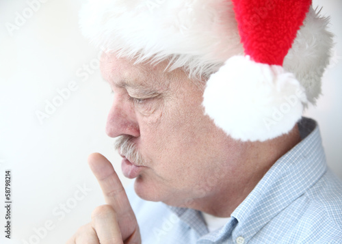 Photo: man in Santa hat with hush gesture man in Santa hat with hush gesture