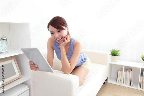 Photo: happy woman using tablet pc on sofa happy woman using tablet pc on sofa