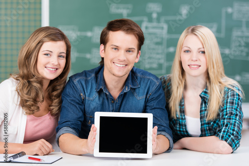 Photo: lächelnde studenten präsentieren etwas am tablet lächelnde studenten präsentieren etwas am tablet