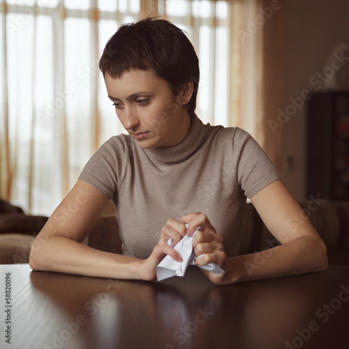 Photo: Sad girl holding a crumpled letter Sad girl holding a crumpled letter
