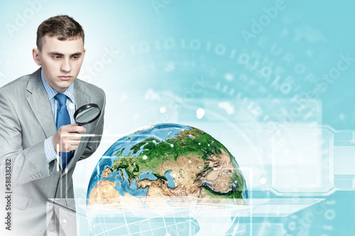 Photo: Man looking in magnifier Man looking in magnifier