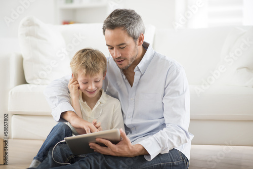 Photo: father and son sharing music headphones father and son sharing music headphones