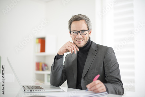 Photo: attractive man working in office attractive man working in office