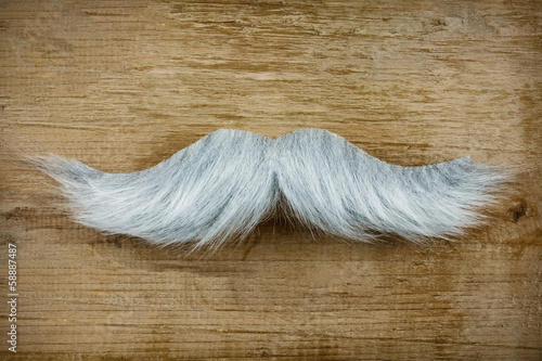 Photo: Fake mustache on an old wooden background Fake mustache on an old wooden background