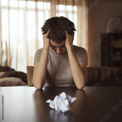 Photo: Crumpled letter lying on the table in front of a woman Crumpled letter lying on the table in front of a woman