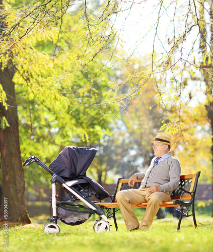 Photo: Grandfather on bench with his nephew in a stroller, in a park Grandfather on bench with his nephew in a stroller, in a park