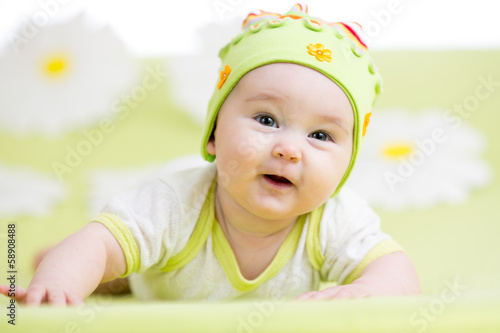 Photo: smiling baby lying on green smiling baby lying on green