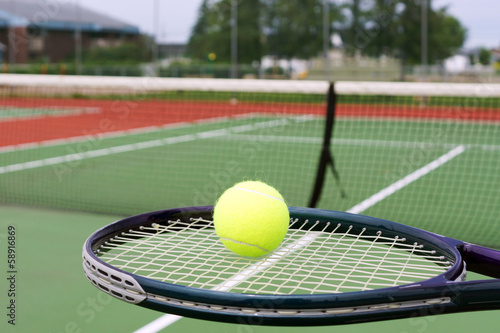 Tennis racket and ball on court - 58916869