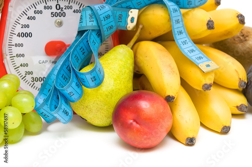 Photo: measuring tape, kitchen scales and fresh fruit closeup. measuring tape, kitchen scales and fresh fruit closeup.