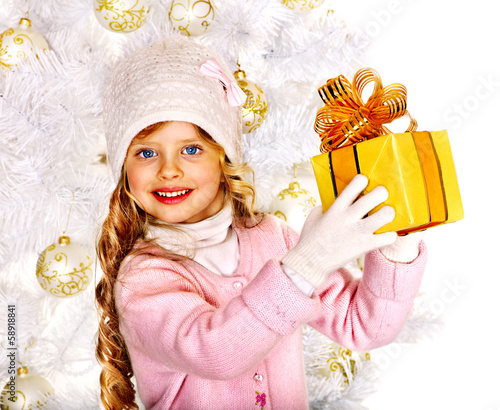 Photo: Child in hat and mittens holding Christmas gift box. Child in hat and mittens holding Christmas gift box.