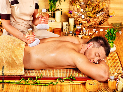 Photo: Man getting herbal ball massage treatments . Man getting herbal ball massage treatments .