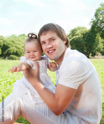 Photo: Young happy father with daughter in the park Young happy father with daughter in the park