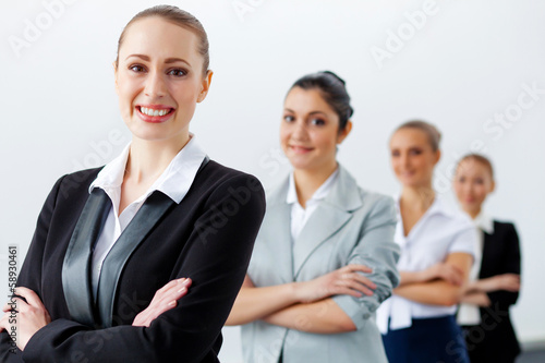 Photo: Four businesswomen standing in row Four businesswomen standing in row