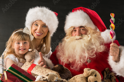 Photo: Santa Claus sitting at home with family - little girl and her mo Santa Claus sitting at home with family - little girl and her mo