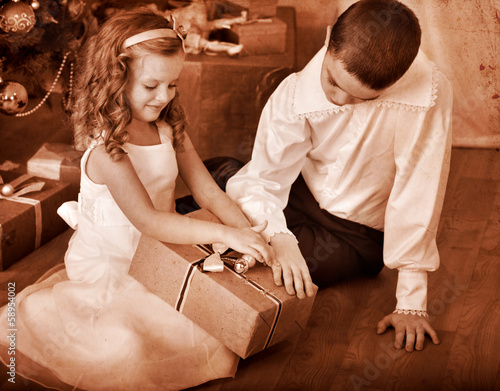 Photo: Children receiving gifts under Christmas tree. Children receiving gifts under Christmas tree.