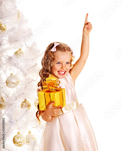 Photo: Child with gift box near white Christmas tree. Child with gift box near white Christmas tree.