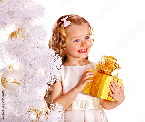 Photo: Child with gift box near white Christmas tree. Child with gift box near white Christmas tree.