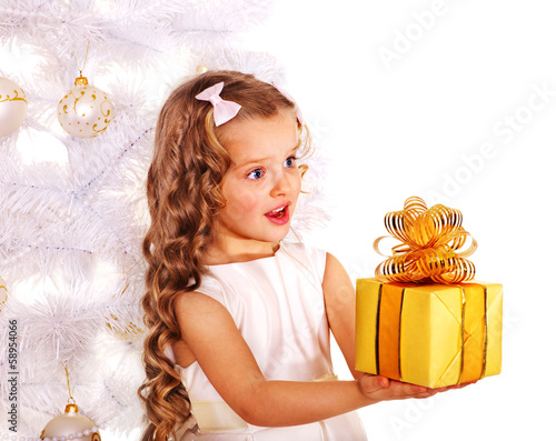 Photo: Child with gift box near white Christmas tree. Child with gift box near white Christmas tree.
