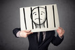 Businessman holding a paper with a prisoner behind the bars on i Businessman holding a paper with a prisoner behind the bars on i
