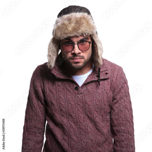 Photo: angry young man in winter clothes and fur hat angry young man in winter clothes and fur hat