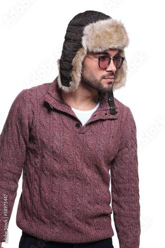 Photo: side view of a young casual man in furry hat side view of a young casual man in furry hat
